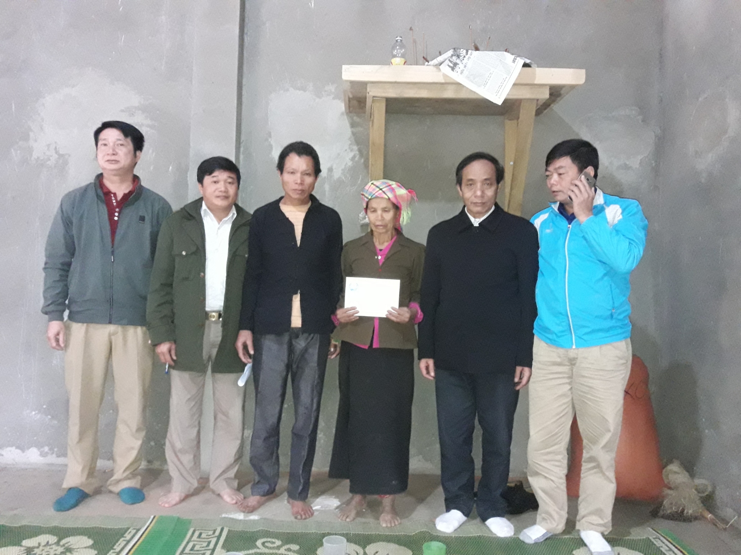 Đồng chí Đỗ Quốc Tuấn - Chủ tịch Liên đoàn Lao động huyện và đại diện cấp ủy, chính quyền xã Mường Khoa  trao tiền hỗ trợ cho bà Lành Thị Đỏm.