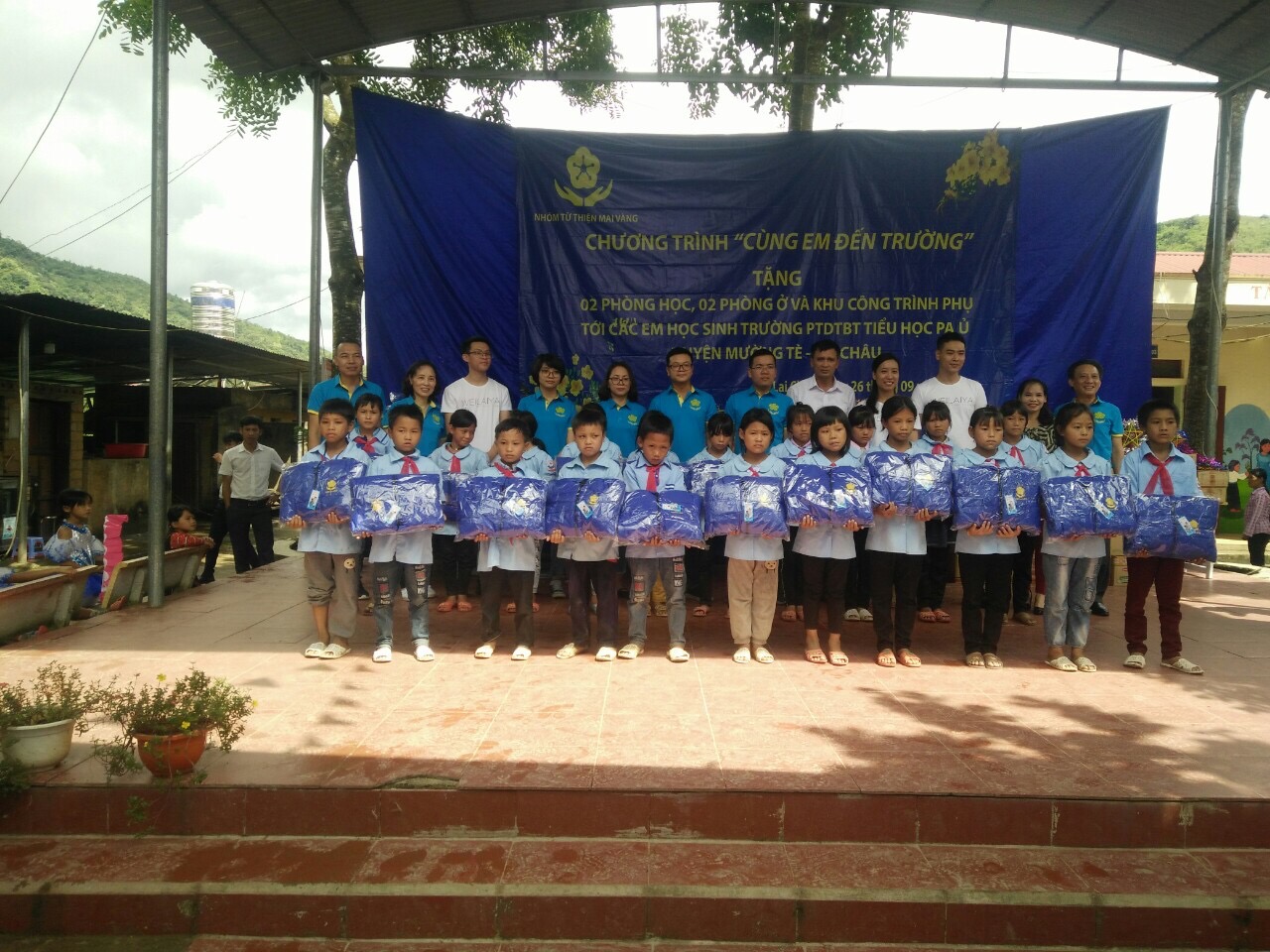 Các thành viên trong nhóm Mai Vàng tặng áo ấm cho các cháu học sinh trường PTDTBT Tiểu học Pa Ủ
